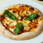 ピザソースにポモドーロを使い、外側パリッと中ふんわりの本場ナポリの味わいの『マルゲリータ』。パルミジャーノ・レッジャーノと水牛モッツァレラ『ボッコンチーノ』の2種類のチーズを使用しています。