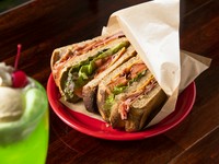 自家製パンにハムやチーズ、新鮮野菜がたっぷり入った一品は、ピクルス入りのマヨネーズとピリッと辛いケチャップが味の決め手。ボリューム満点なので、シェアして楽しむのがオススメです。