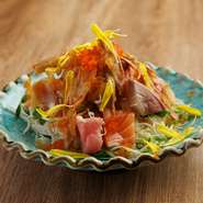 新鮮なサラダの上に旬魚の切り身を盛り、特製の生姜ドレッシングをかけた独自のサラダ。