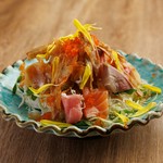 新鮮なサラダの上に旬魚の切り身を盛り、特製の生姜ドレッシングをかけた独自のサラダ。