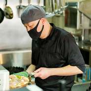 垣根をつくらない、気さくでフレンドリーな接客。料理のリクエストから、ちょっとした世間話まで、カウンター越しに弾む会話が、一日の疲れを癒します。スタッフお揃いのつなぎ姿もキュート！