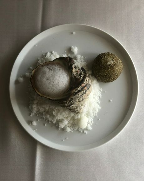 海岸の岩場をイメージした盛り付けが印象的な『サザエの海苔と黒にんにくバター和え』