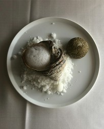 海岸の岩場をイメージした盛り付けが印象的な『サザエの海苔と黒にんにくバター和え』