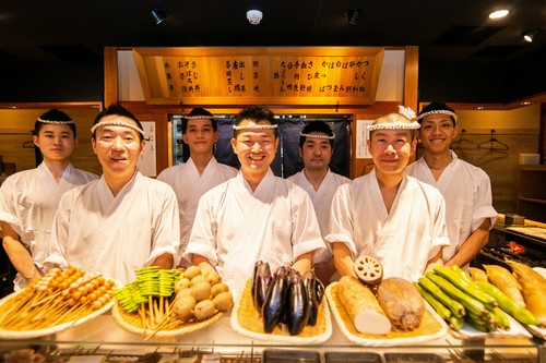 笑顔で出迎える料理人