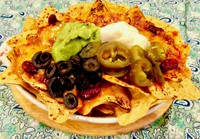 当店人気の本格派ナチョス。コーントルティーヤチップスにひき肉とキドニービーンズのソース。レッドチェダーチーズ、ワカモレ、サワークリーム、ハラペーニョ、ブラックオリーブをのせてオーブンで焼き上げます！