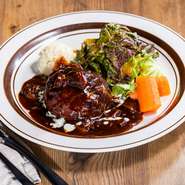 洋食の名店「レストラン大宮」のオーナーシェフ大宮勝雄が手掛ける当店のハンバーグステーキは、肉の旨味と食感を最大限引き出す為、肉の比重を多くし、噛み応えがあり、肉そのものの食感が味わえます。香ばしく程よい苦みを加えた大人の味に仕上げた特製のデミグラスソースはハンバーグステーキとの相性が抜群です。