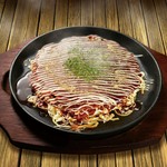 お好み焼きと焼きそばを合わせた関西のソウルフード！こて吉では、太麺の焼きそばとお好み焼きの生地を卵でつなぎ、ボリューム感あふれる外見と、それに違わない食感が特徴の逸品となっています。