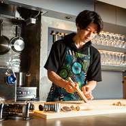 職人が目の前でゲストをもてなす、鮨店をイメージしたという店内。カウンターにはパスタマシンが設定されており、オーナーシェフがゲストの目の前で調理。パスタづくりの光景すべてを目の当たりにできます。