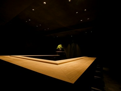 白木のカウンター席に盆栽が飾られた、シンプルでオシャレな空間