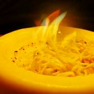 ゲストの目の前で仕上げる絶品パスタ。長期熟成させてつくられるリトアニア産チーズの器でパスタをあえています。一口食せば、濃厚な味わいがクセになること請け合いです。