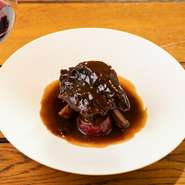 ボルドーのメルロー種ワインでじっくりと煮込んだ赤ワイン煮です。その日の肉質に合わせ6～8時間かけ、箸でも食べられるギリギリのやわらかさに。シェフ自身が食べたいと思える自慢の味わいです。
