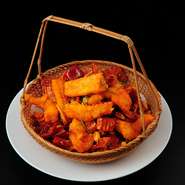 プリッと揚げた海老と唐辛子を、特製のスパイスで炒めました。香味高いお酒に合う人気料理。唐辛子もサクサクと食べられます。