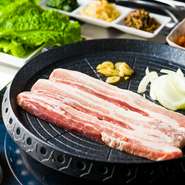 1.3cm厚と厚めにスライスした豚バラの三枚肉を、熱々の鉄板で焼いていただく『サムギョプサル』。ジューシーな豚バラは、食べやすく切ってサンチュで巻き、お好みで辛味噌やキムチ、ナムルを添えてどうぞ。
