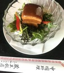 厚切りに切った三層の皮付き豚バラ肉を煮・焼・蒸などの調理工程で脂質が取り除かれコラーゲンの含んだゼラチン化した汁と中華独特の風味をもつ薬膳・薬味を使って仕上げた人気の料理トンポーロです。　