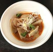 茹でた水餃子にピリ辛の胡麻ソース汁をかけています。