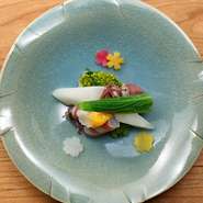 独活や菜種、うるいなどの春野菜とホタルイカ、車海老を使った春らしい逸品。上に添えた黄身酢とともにお召し上がりいただきます。