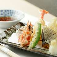 その日に豊洲市場から仕入れた海の幸や、旬の野菜の天ぷらが多種多様に楽しめる一皿です。内容は季節や仕入れ状況により変わるので、何が出てくるかはその日のお楽しみ。
