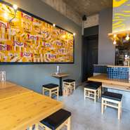 壁の一部をビールの段ボールでカラフルにデザインしたり、ビールケースをランプシェードに見立て照明を飾ったりするなど発想がどれもユニークです。料理を待つ間、オリジナリティ溢れるインテリアを眺めて楽しんで。