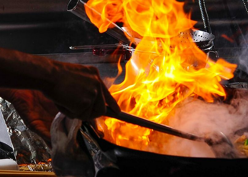 炎を巧みに操りながら、料理を完成させていく