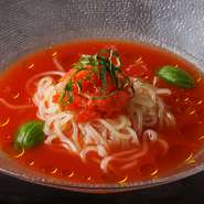 北海道で30年続く江本自然農園の無施肥・無農薬果樹栽培トマトジュースを贅沢に使った、夏にぴったりなトマト冷麺です。鶏がらと牛すじをMIXした濃厚スープにトマトジュースをブレンドすることで、コクと甘みと酸味をバランスよく仕上げました。オリーブオイルとバジルを加えることでフレッシュな香りをお楽しみ頂けます。トマトのグラニテの冷たい食感をアクセントに、最後の一滴まで飲み干したくなる逸品です。