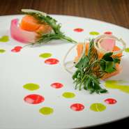 中心部分をレアな状態に仕上げるミキュイで、サーモンのコクと旨みを引き出します。味を引き締め、彩りを添えてくれるのは甘酸っぱいラズベリーソース。香草が味わいと彩りにアクセントを演出しています。