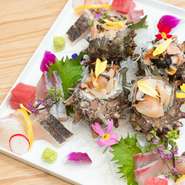 その日に入ったおすすめの魚を、ボリュームたっぷりに盛り付けた『刺身盛り合わせ』。赤身・白身・貝類などが華やかに盛り付けられた、色とりどりの一皿です。価格は、1人前。