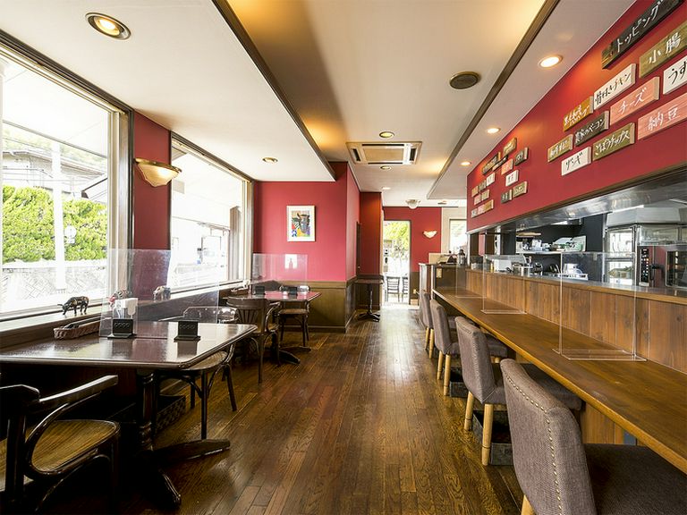 カウンター席あり。赤を基調にした落ち着いた雰囲気の店内