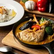 店自慢のスープカレーに合わせるのは、ボリューム満点のチキンレッグ。じっくり煮込んでから油でカリッと揚げ、ジューシーな旨みを閉じ込めます。彩りのよい8種の野菜が添えられて、栄養バランスも抜群です。