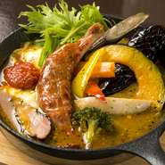 彩りのよい8種の野菜に食べごたえ抜群の骨付きウインナー、北海道の農家のベーコンが入ったボリューム満点の一品。香ばしくコクのある炙りチーズやタイム風味のトマトソースが添えられ、“味変”も楽しめます。