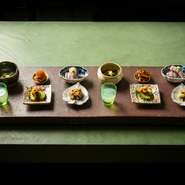 四季折々の魚介や野菜を一口ずつ味わえるお通し。季節の味覚が美しく豆皿に盛り付けられており、目で見ても、食べても楽しい魅力いっぱいの一皿です。