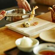 東京の街並みが一望できる空間で味わう、旬の素材を活かした天ぷら料理。毎月1回メニューを変更しており旬の味をお楽しみいただけます。カウンター席の目の前には揚げ台があるので揚げたてを熱々の状態でご提供。