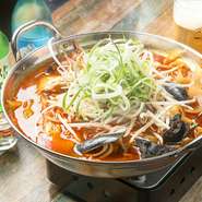 新鮮な魚介類とうどん、ネギをたっぷりのせた鍋。辛めのスープはお酒との相性抜群です。