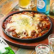 イイダコと三枚肉の辛炒め鍋。しっかりと下味をつけたイイダコととろけるチーズが絡まり、一度食べたら忘れられないおいしさだと評判です。