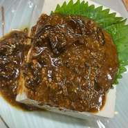 麹、醤油、青唐辛子を熟成させたものを豆腐にかけた逸品。「旨くて辛い」と人気のメニューです。お酒のつまみにも、ごはんのお供にも最適。クセになるおいしさに、お箸が止まりません。