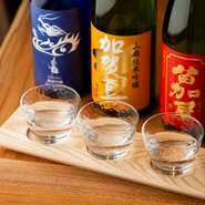 日本酒のセレクトにこだわり、料理に寄り添い引き立てる銘酒を厳選。地酒を中心に限定酒や季節の一本まで充実しています。自分で選べる3種が飲み比べできるセットは大人気。
