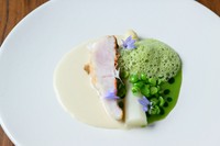 絶妙な火入れ技で繰り出す魚料理は、素材の持ち味をさらに高めるおいしさ。写真の一例は、八丈島産金目鯛のポワレに白アスパラガスを添え、白ワインソース、豆のソース、山菜のエスプーマで季節の彩りと滋味を表現。