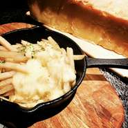 とろとろの削りたてチーズをポテトにつけて頬張る、大人にも子どもにも人気のメニュー。ナッツのような香りがふんわり漂います。