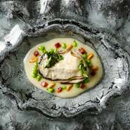 タラをオリーブオイルで煮込んで乳化させるバスク地方の伝統的調理法にイベリコ豚の脂を加えてコクを出したマテウ流ピルピルソースに浮かべた岩牡蠣。チョリソー、松の実、エンドウマメなどが食感のアクセントに。