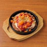 ぷりぷりのたこをスパイシーなサルサソースで炒めた、食欲そそる一皿。鉄板の熱気と香辛料の香りがたまらない！