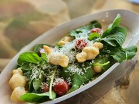 結び目をつくって揚げたピッツァ生地とミニトマト、ルッコラをオリーブオイルで和えたナポリのピッツァイオーロの創造力あふれる一品。