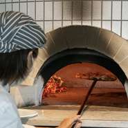 本場イタリアから仕入れた素材を使ったピザは、店内に特別にあつらえた薪窯で焼くスタイル。職人の手で一枚ずつ丁寧に焼きあげられたピザは、パリッと香ばしい食感も魅力。アツアツのピザをぜひご堪能あれ。