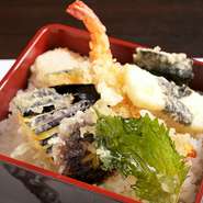 プリッとした食感が楽しい海老とその時期にもっとも旨みを増す新鮮野菜。厳選した食材をカラリと揚げた店主自慢の天ぷらは、熱々ご飯と相性抜群。やさしい甘さの丼つゆと相まって、箸が止まらないおいしさです。
