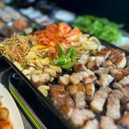 韓国式の豚バラ焼肉は、自家製ナムルやキムチなどと一緒に鉄板で運ばれて来ます。一口大にカットされた肉はカリッとジューシーに焼き上げられビールと相性抜群。自家製サムジャンが旨みをいっそう引き立てます。