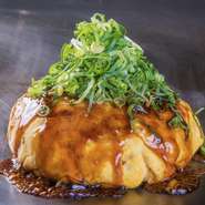 肉・玉子ダブル・イカ天・大葉・ねぎかけ・そばもしくはうどんが入ったボリュームたっぷりなお好み焼き。コロンと丸い形がなんとも愛らしい、大葉の爽やかさがアクセントになった一番人気のメニューです。