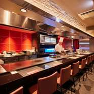 ベーシックカラーである赤を中心に、シックな雰囲気に包まれる鉄板焼店。店内には、臨場感高まるカウンター席と、プライベートタイムを素敵に演出する個室、グループ利用に最適なテーブルが完備されています。