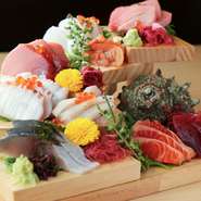 八王子北の市場から仕入れた新鮮な魚たち。日によってさまざまな旬の恵みを楽しめます。店内カウンター上の黒板では、当日のオススメも紹介中です。来店時はぜひチェックを。