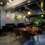 シックな内装と落ち着いた照明がとても寛げる店内。10鉢以上ある大きな観葉植物が、より一層居心地の良さをつくっています。テーブル席だけでなくカウンター席やベンチシートのソファー席も人気です。