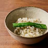 鶏挽肉は、薪火の薫香をよく纏うように皮など脂の部分を多めに加えています。ザルに入れ、炎で炙るその様子も実にダイナミック。土鍋に薪を入れるのは、白飯にも薫香をつけるため。