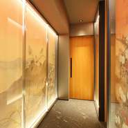 壁面の日本画が美しいアプローチの奥にメインのカウンター席が