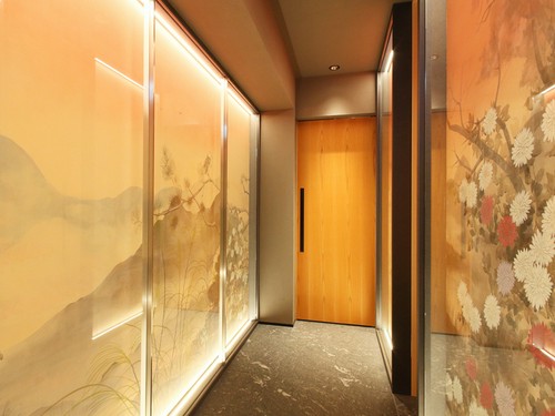 壁面の日本画が美しいアプローチの奥にメインのカウンター席が